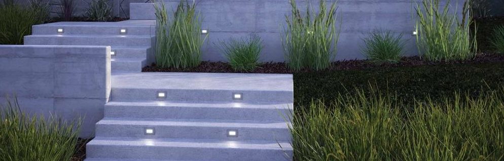 Outdoor step lights shine on stone steps in front of a modern house | Capitol Lighting