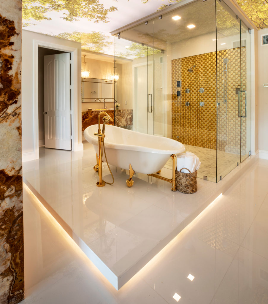 Beautiful gold accented bathroom with a raised tub area that has under-foot lighting