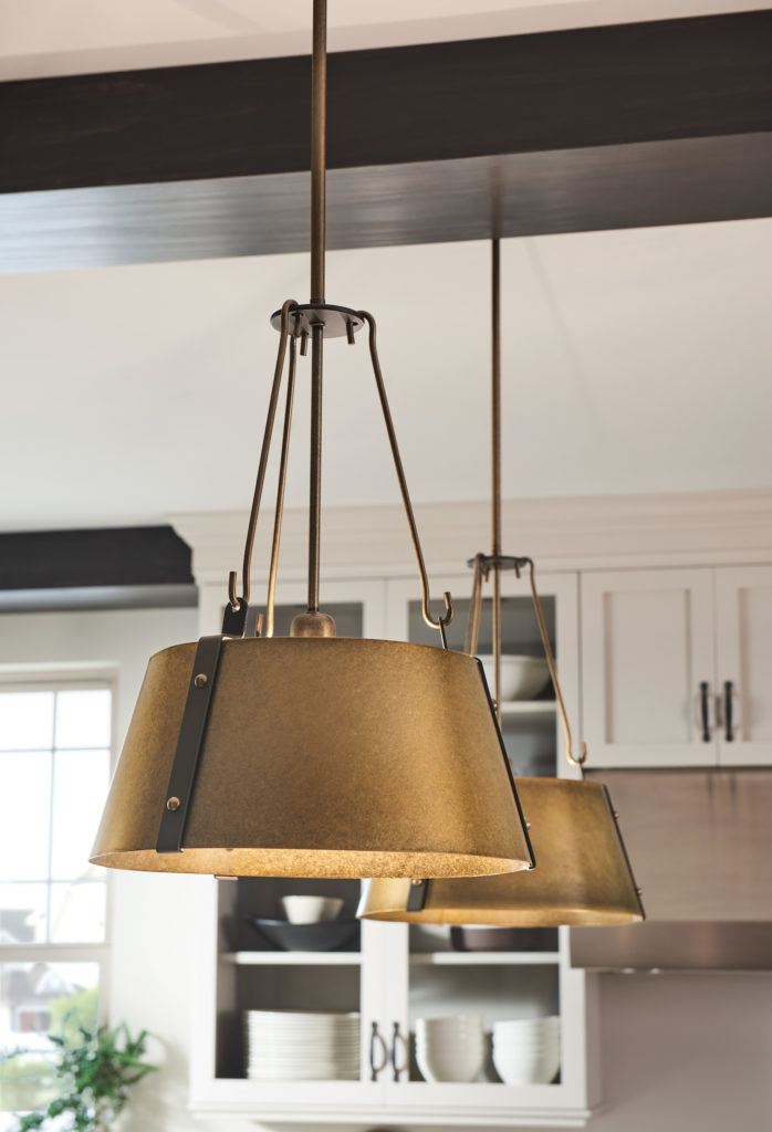 The warm brass finish of the Cartwright by Hinkley Lighting pops against off-white cabinets and dark wood beams