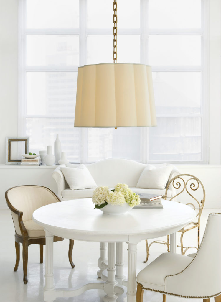 The Barbara Barry Simple Scallop Pendant has a curvy drum-style shade that diffuses light around a round white dining table