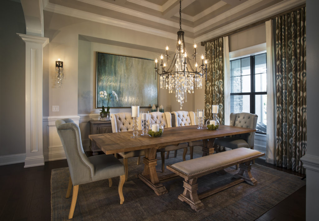 Feiss Cascade Chandelier hangs over wood farmhouse table in traditional dining room