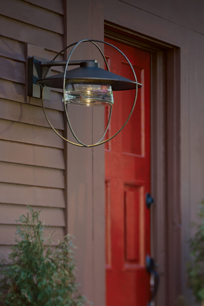 Geometric lighting fixtures belong outside, too, like this Halo Wall Light flanking a red front door