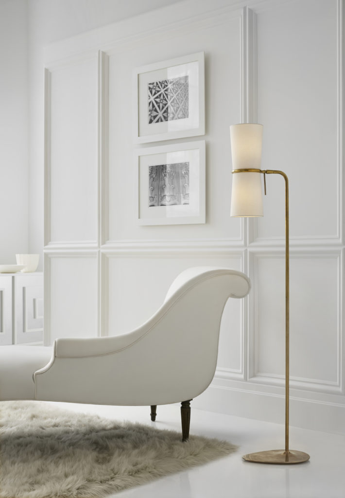 Aerin Clarkson 58-Inch Reading Lamp stands next to white chaise in a minimalist room
