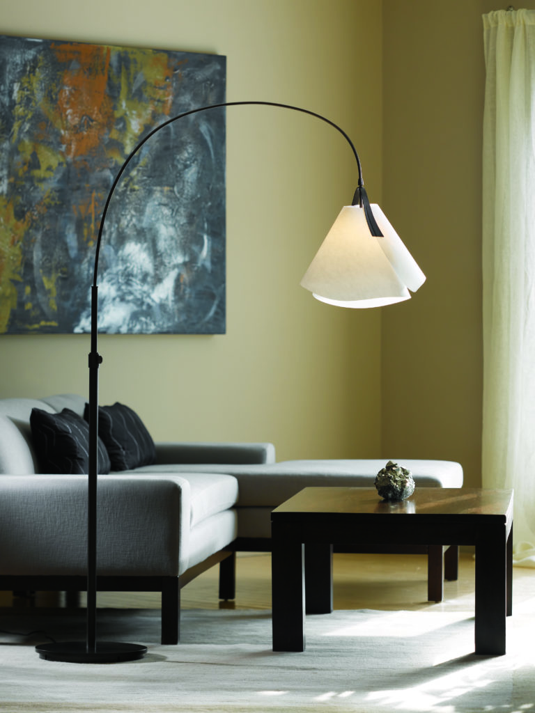 Mobius 66-Inch Arc Lamp reaches over the coffee table in a modern minimalist living room