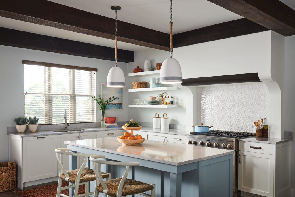 This white kitchen with a coastal blue island is complemented by two Nash mini pendants | Capitol Lighting