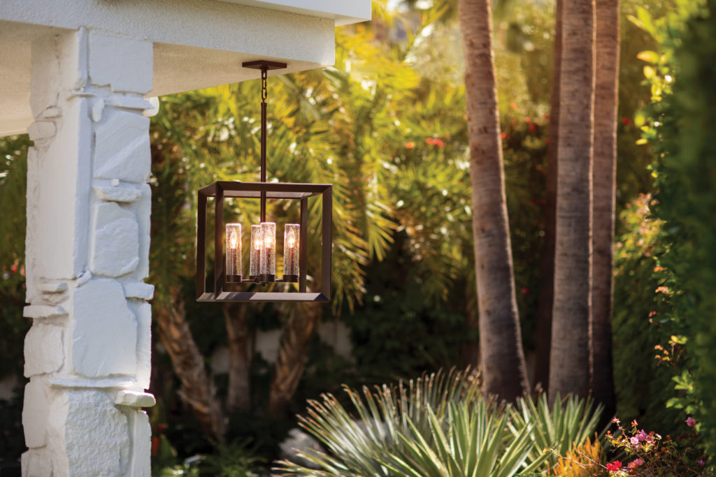 The square, seeded-glass Rhodes hanging lantern stands out on a back patio with landscaping | Capitol Lighting