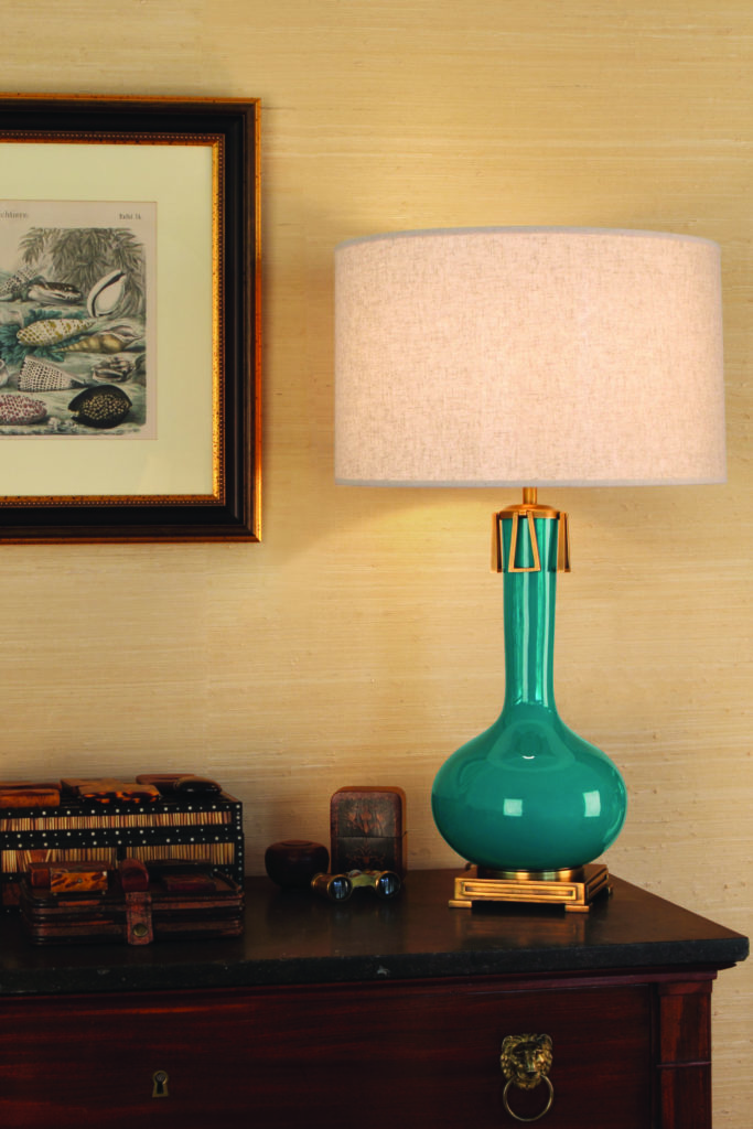 Athena table lamp has turquoise blue base and gold accents that complement dark wood dresser.