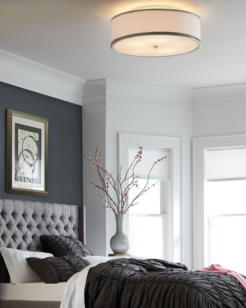 The Feiss Pave Flush Mount in polished nickels adds warm yellow glow over gray-toned bedroom | Capitol Lighting