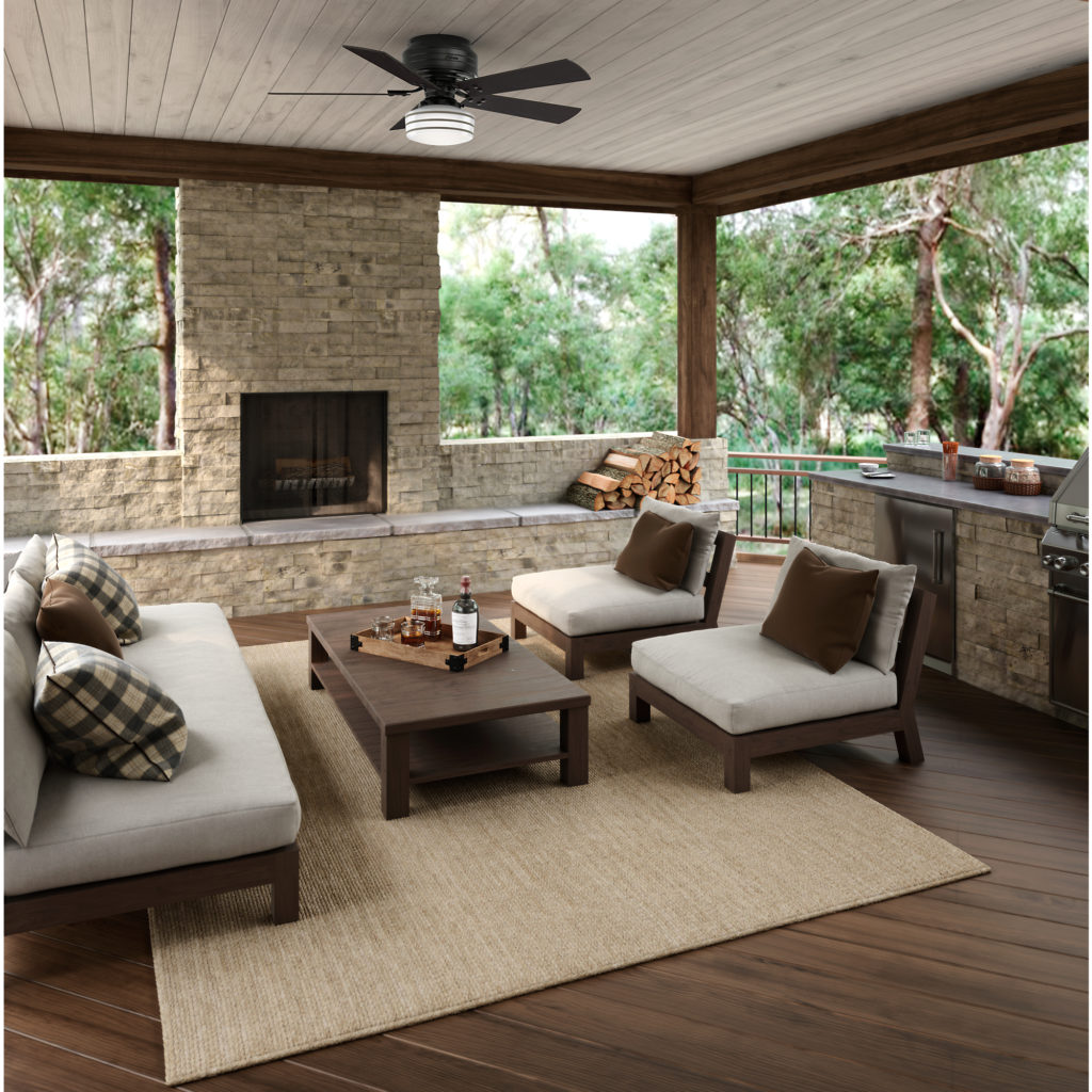 Cedar Key outdoor ceiling fan adds to the masculinity of a covered living room in the woods. 
