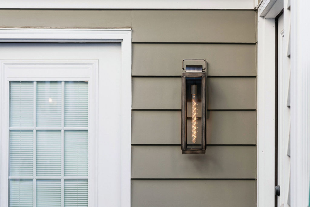 The Sag Harbor wall light adds industrial decor to your outside entryway.