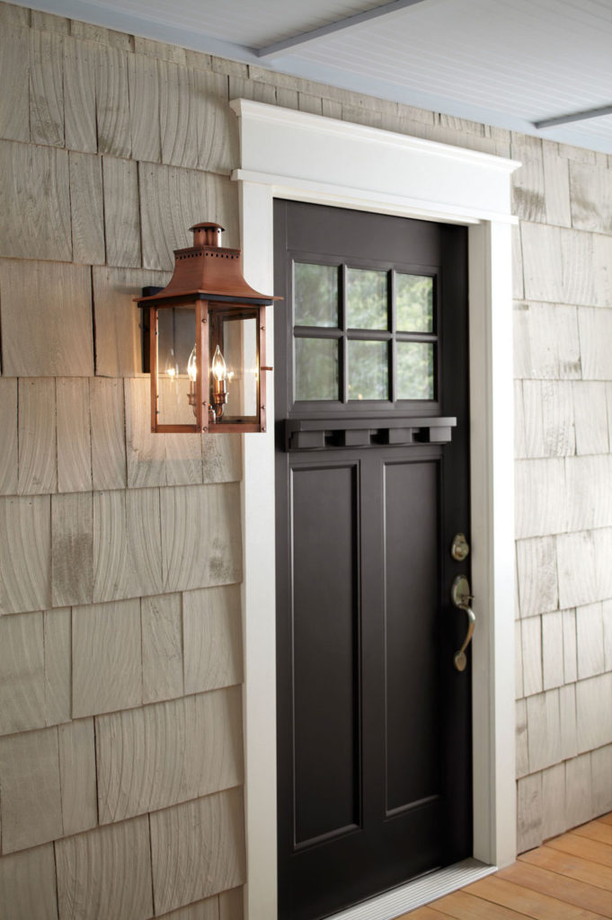 The Chalmers outdoor wall lighting design has old-world charm next to dark wood door.