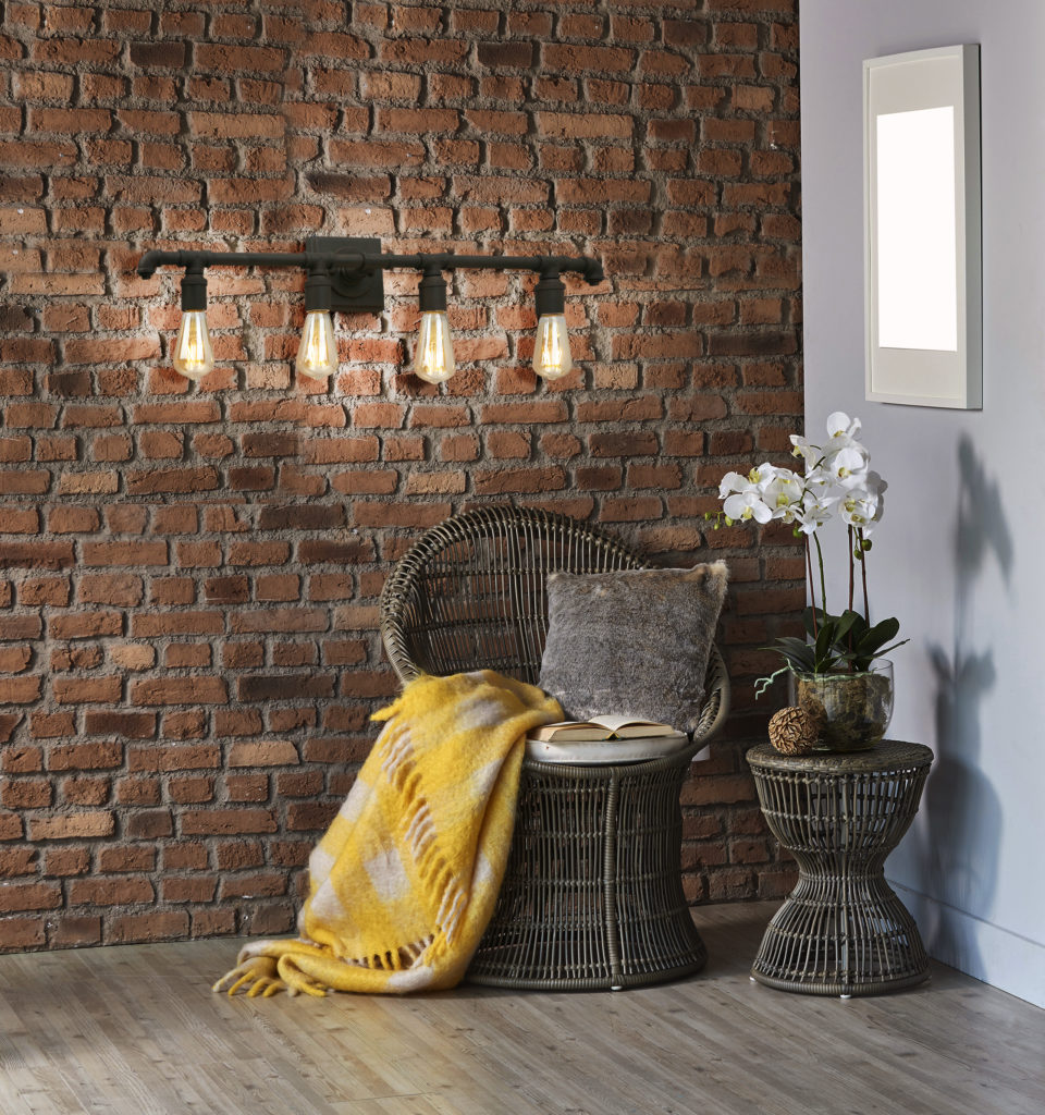 A Eglo Wymer 4-Light sconce attached to a brick wall.