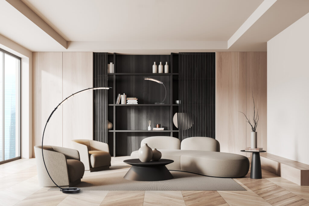 A modern living room featuring a Glissade Table Lamp with a white lampshade, placed on a wooden side table next to a gray armchair.