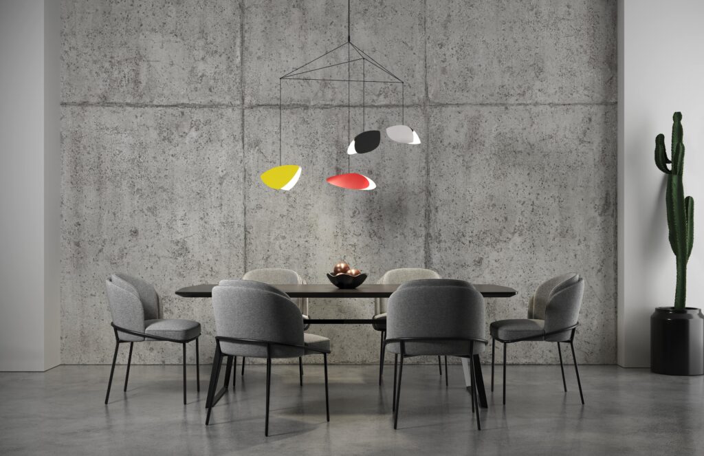 Modern dining room with minimalist Scandinavian design, featuring grey chairs, a dark table, and colorful pendant lighting against a concrete wall.