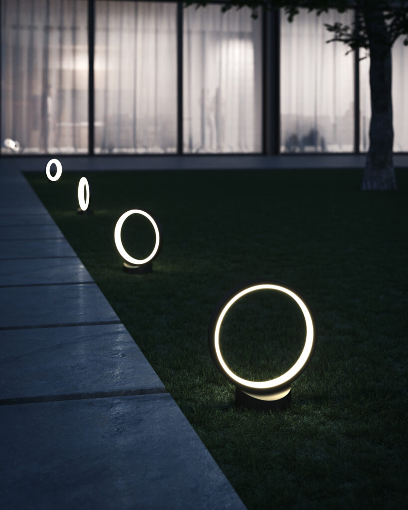 Modern circular pathway lights illuminate a grassy lawn next to a concrete path and a building with large windows at dusk.
