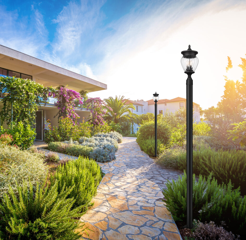 Black post lights lining a winding stone garden path.